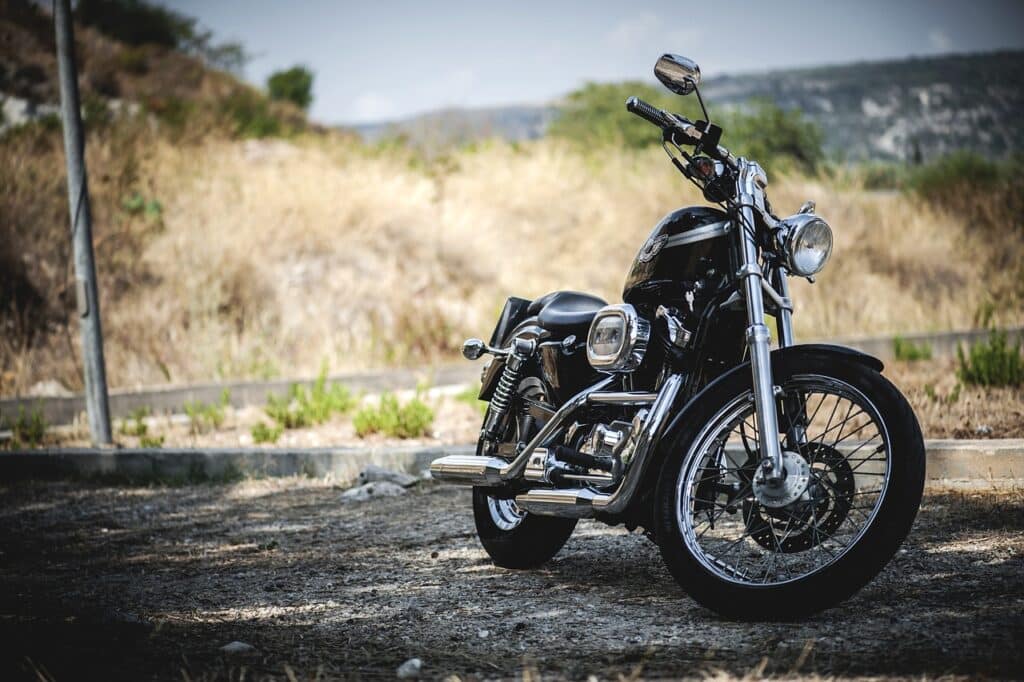 Motorcycle parked near grassy, hilly field