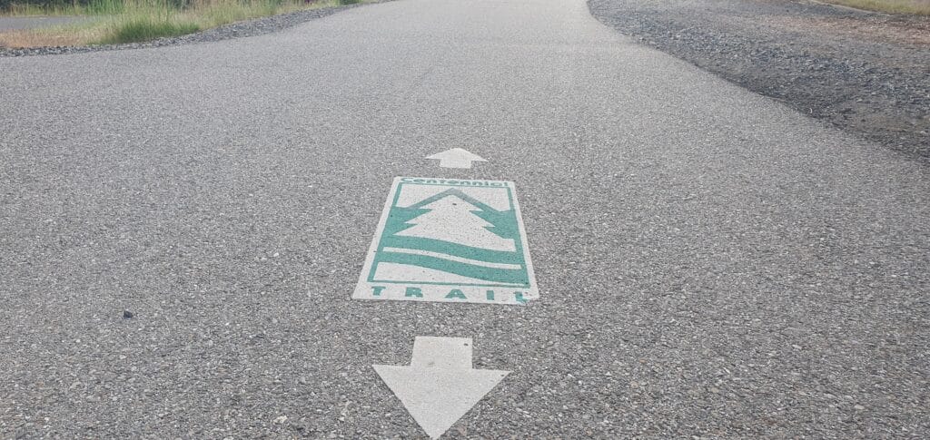 Photo of Centennial Trail symbol and arrows painted on Spokane's bike and pedestrian path.